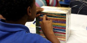 Boy looks through stack of books