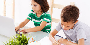 two kids sitting at desk doing homework