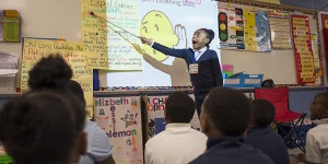 girl stands in front of classroom