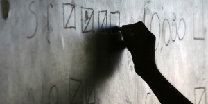 An election official notes on a chalkboard in a national referendum in Santa Cruz