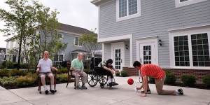 adults with disabilities in driveway playing basketball