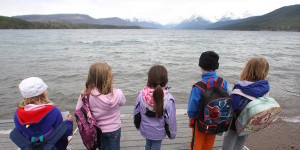 young students standing looking over a lake