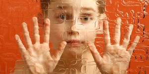 Student with autism looking through glass