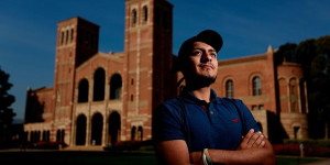 Latino student in front of college building