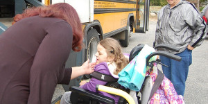 student with wheelchair going on bus