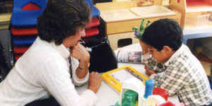 Teacher sitting with student