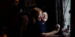 mom with glasses hugging daughter