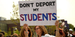 teaching holding up sign "don't deport my students"