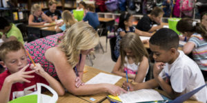 female teacher helping students