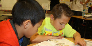 one male student helping another to read