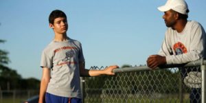 male teen runner with cerebral palsy with coach