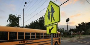 school bus with pedestrian crossing walk sign
