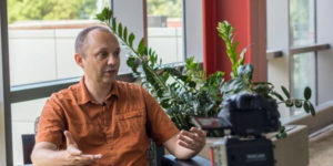 professor in casual orange shirt