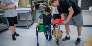 student with walker with a wooden box