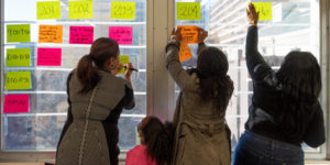 teachers posting sticky notes on window