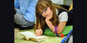 young girl with glasses reading