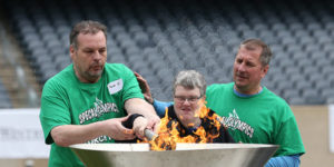 athletes lighting the olympic torch